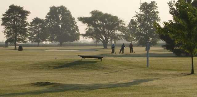 A view of a tee and golfers in the distance at Hollow Acres Golf Center