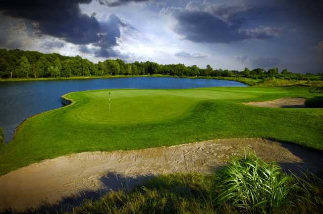 A view of the 15th green surrounded by water at Noble Hawk Golf Links