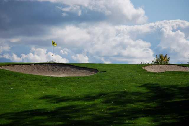 A view of a green protected by bunkers at Cedar Knoll Country Club