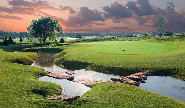 A view of a green surrounded by water at Belmar Golf Club.