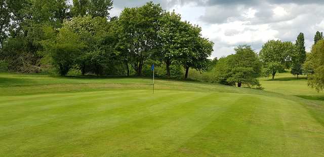 A sunny day view of a hole at Queens Park Golf Club.