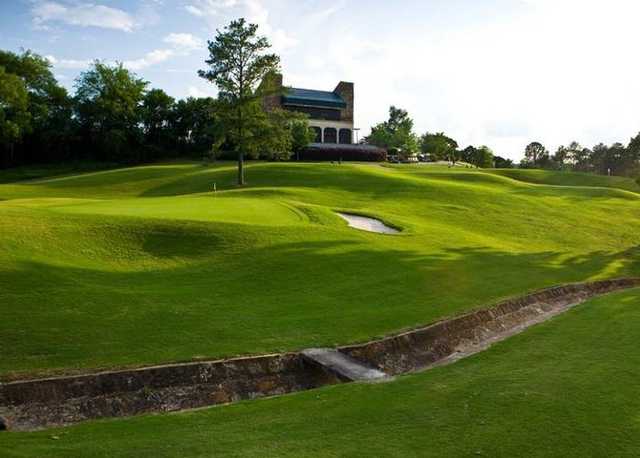 A view of the clubhouse with green in foreground at Highland Park Golf Course
