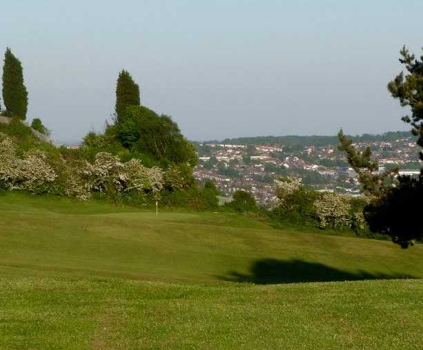 A view from a fairway with spring blossom trees protecting a green at Dudley Golf Club