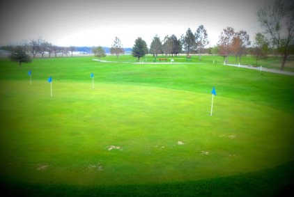 A view of the practice putting green and a fairway in background at Stillwater Golf Course.