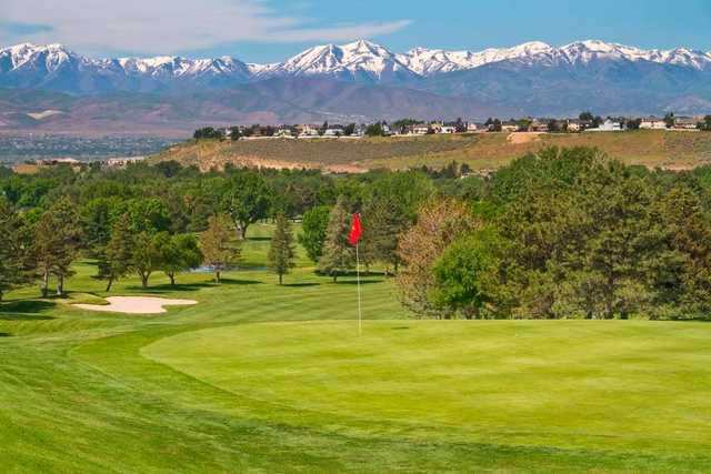 A view of a green and mountains covered by snow in the distance at Hidden Valley Country Club.