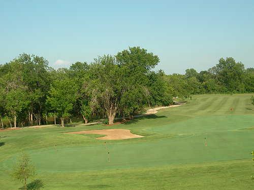 A view of the practice putting green and a fairway from The Links at Stillwater Golf & Country Club