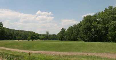 A view of green with narrow path in foreground at Cherry Valley Golf Course