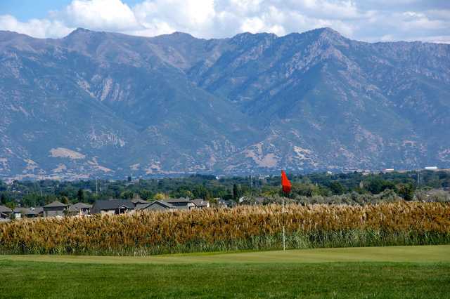 A view of a green with mountains in background at Crane Field Golf Course
