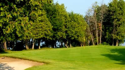A view of a green protected by bunker at Island Brae Golf Club