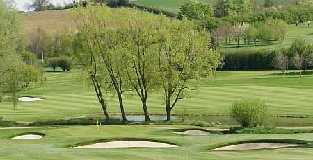 A view of a green guarded by bunkers at Market Harborough Golf Club