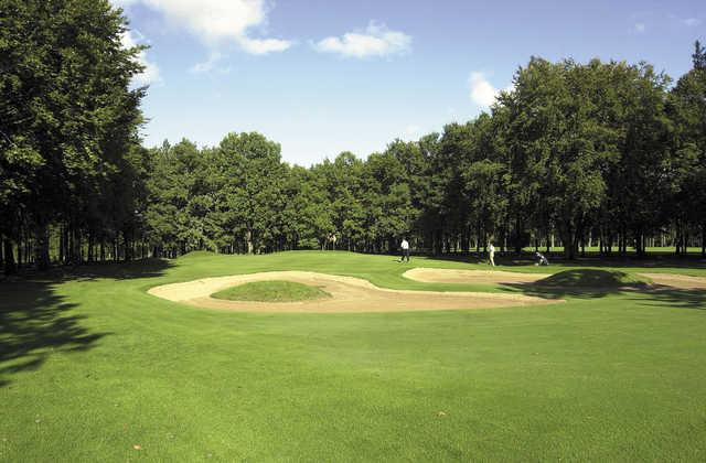 A view of a green guarded by sand traps at Dijon-Bourgogne Golf Club