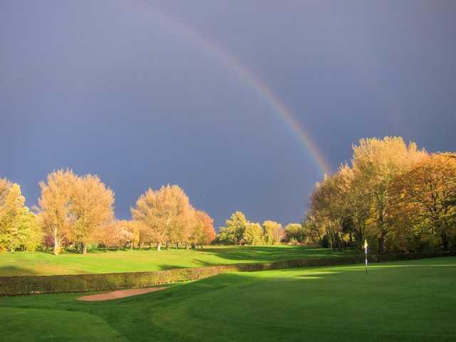 Beautiful shot of the 18th hole with a rainbow going over the course at Heaton Moor Golf Club