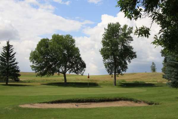 A view of a green protected by a bunker at Sidney Country Club
