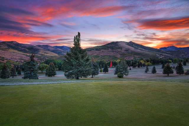 A sunset view of a green at Mountain Dell Golf Course.