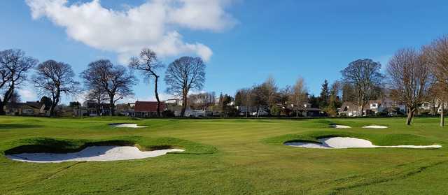 A view of a green surrounded by a collection of bunkers at Aberdour Golf Club.