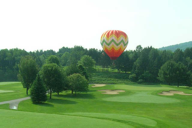 A view of a green protected by bunkers at Quechee Club