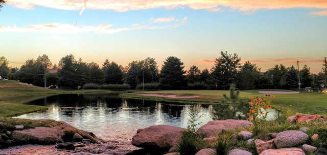 A sunset view of a green with water and sand traps coming into play at Willow Creek Country Club.