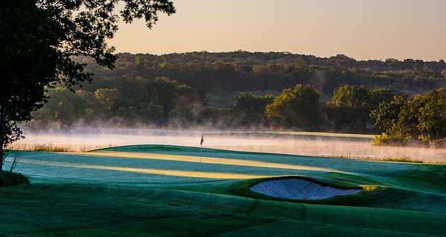 A view of a green surrounded by mist at Karsten Creek Golf Club