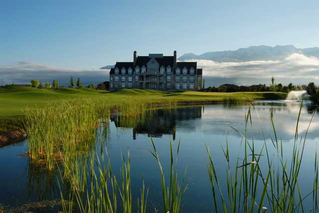 A view of a green with water coming into play and the clubhouse in background from The Links At Sleepy Ridge.