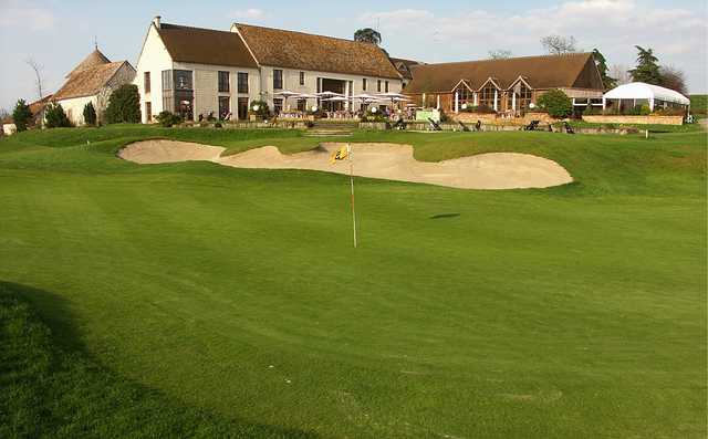 A view of a hole and the clubhouse at Stade Francais Courson Golf Club.