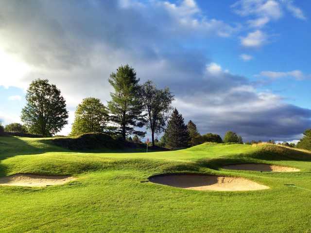 A view of a green protected by bunkers at Rutland Country Club