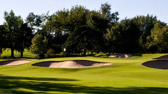 A view of a green protected by a collection of tricky bunkers at Oklahoma City Golf & Country Club