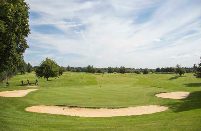 A view of a green protected by bunkers at Hurtmore Golf Club