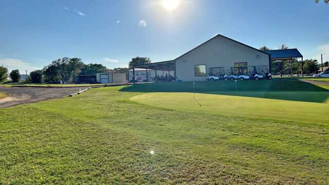 View of the putting green and clubhouse at Sayre National Golf Course.