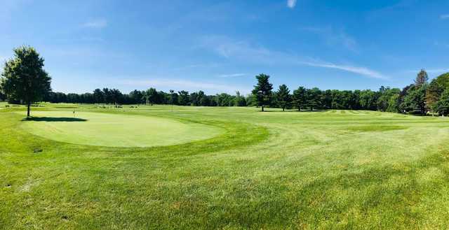 A sunny day view of a fairway and the practice putting green at Brookshire Golf Club.