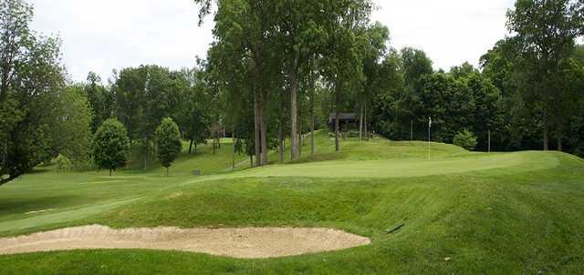 A view of a green protected by a bunker at Delaware Country Club