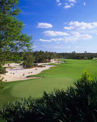 A view of green and fairway with sand traps on the left side at Calusa Pines Golf Club