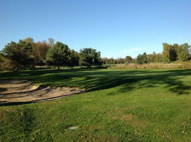 A view of a green protected by a bunker at Alburg Country Club
