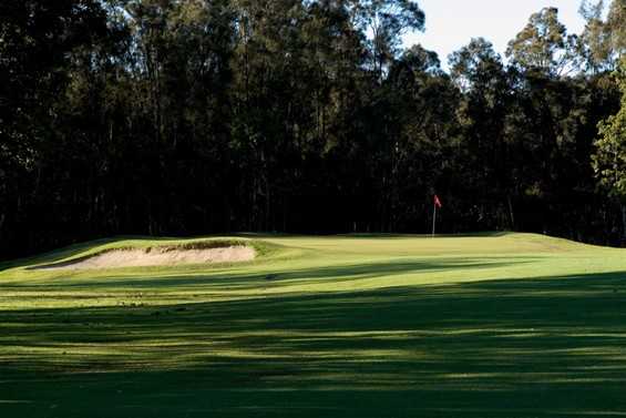 A sunny view of a hole guarded by bunker at Helensvale Golf Club