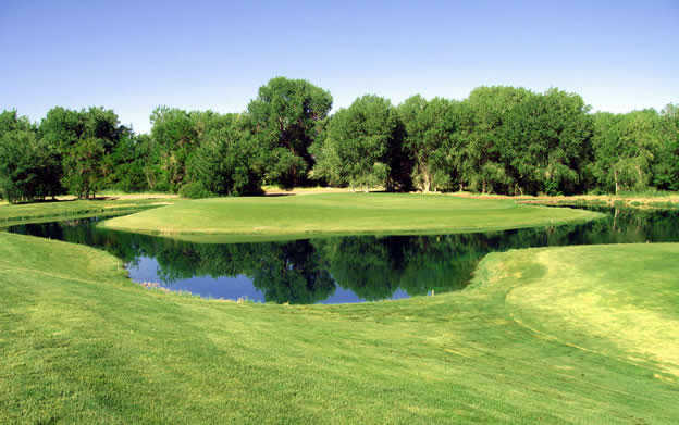 A view of the 8th green surrounded by water at Paradise Golf Resort