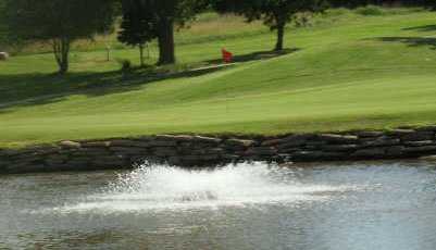 A view over the water of the signature hole #3 at Crimson Creek Golf Course