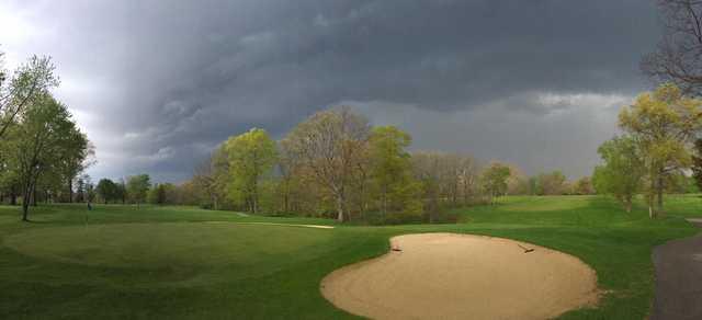 A spring day view of a hole covered by dark clouds at Meshingomesia Country Club.