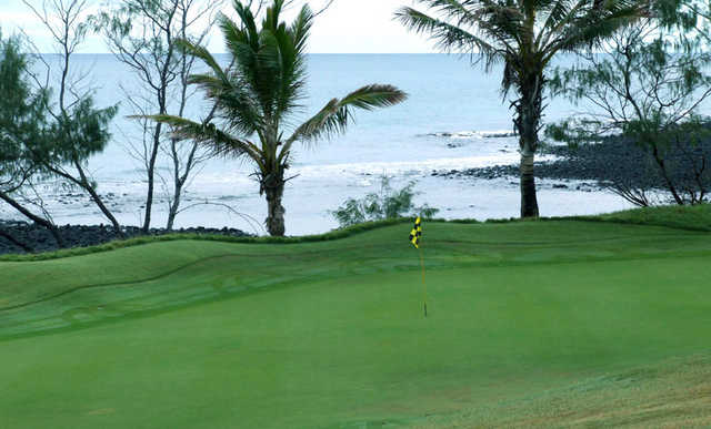 A view of green with water in background at Coral Cove Golf Club
